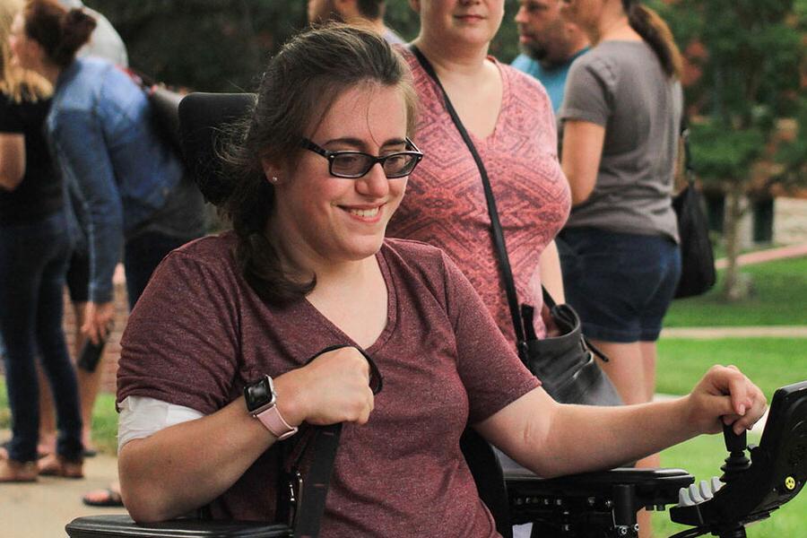Female student navigates her wheelchair during new student welcome event.
